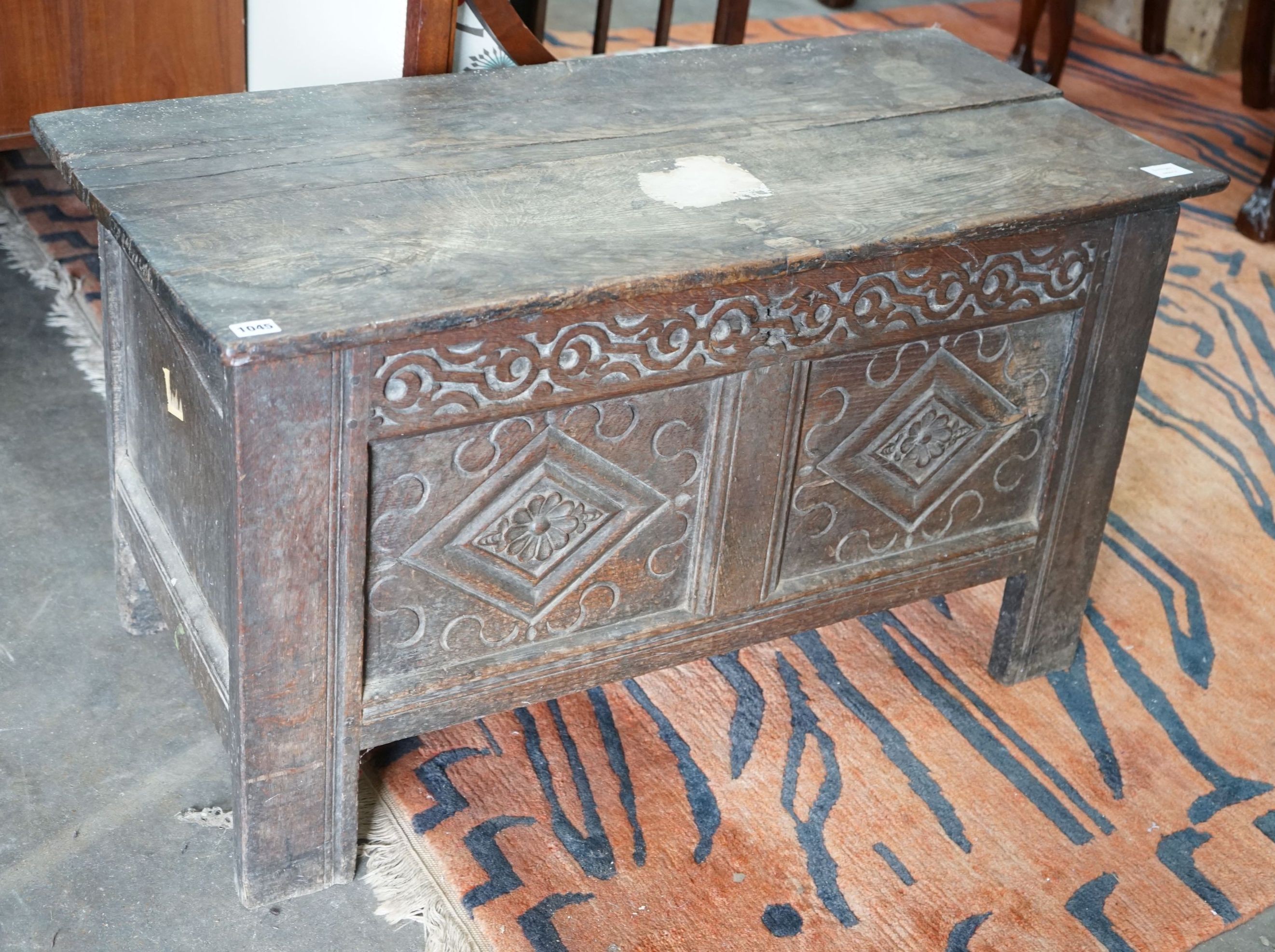 A small 18th century carved oak coffer, with a carved panelled front, length 102cm, depth 47cm, height 57cm